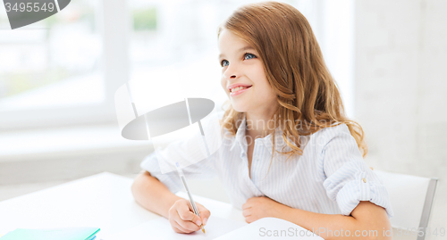 Image of student girl writing in notebook at school