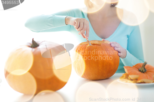 Image of close up of woman with pumpkins at home