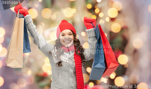 Image of happy woman in winter clothes with shopping bags
