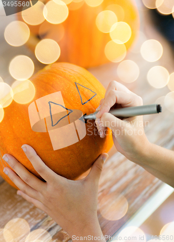 Image of close up of woman with pumpkins at home
