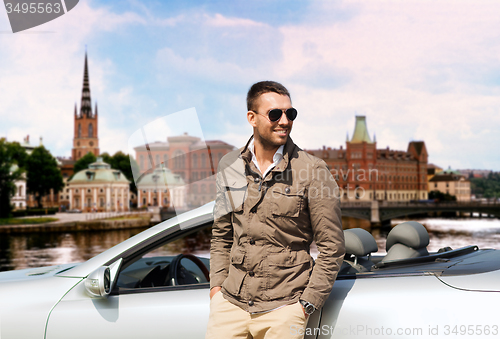 Image of man near cabriolet car over city of stockholm