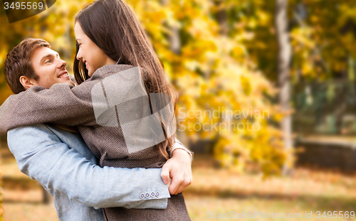 Image of smiling couple hugging over autumn background