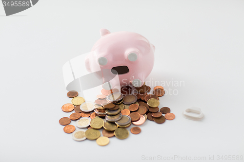 Image of close up of euro coins and piggy bank on table