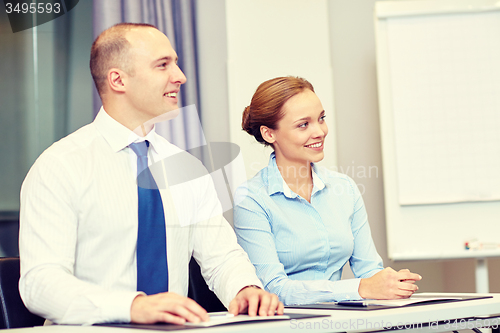 Image of group of smiling businesspeople meeting in office