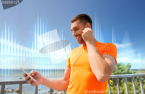 Image of smiling young man with smartphone and earphones