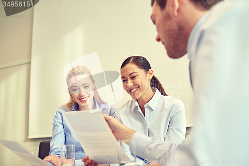 Image of group of smiling businesspeople meeting in office