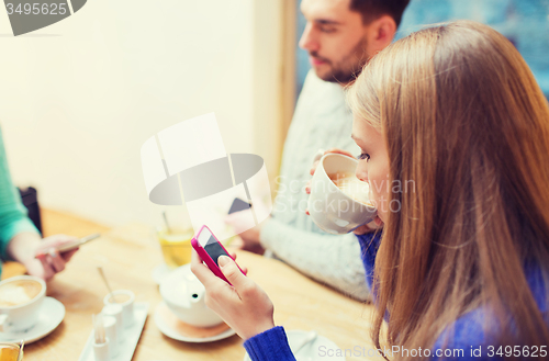 Image of couple with smartphones drinking tea