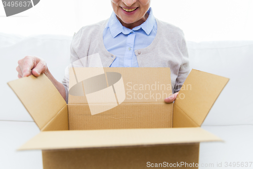 Image of close up of senior woman with parcel box at home
