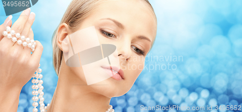 Image of beautiful woman with sea pearls beads in hand