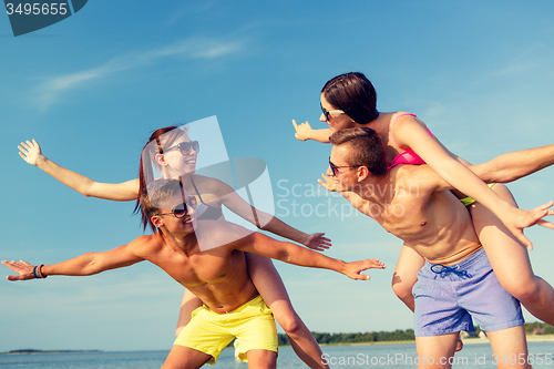 Image of smiling friends having fun on summer beach