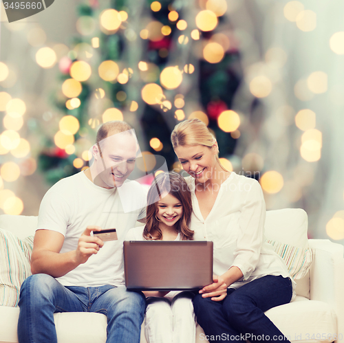 Image of happy family with laptop computer and credit card