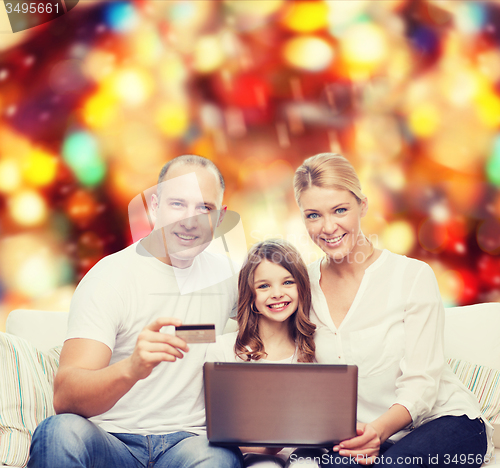 Image of happy family with laptop computer and credit card