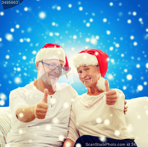 Image of happy senior couple in santa helper hats