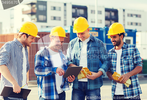 Image of group of smiling builders with tablet pc outdoors