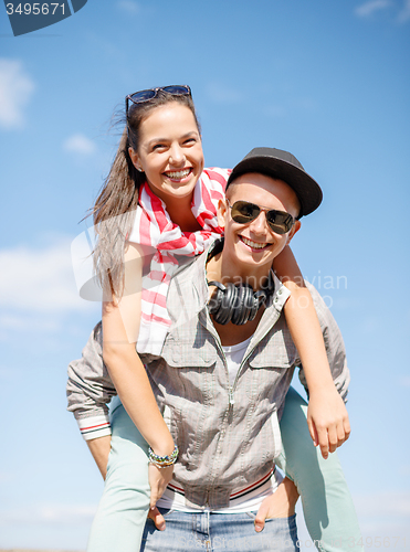 Image of smiling teenagers in sunglasses having fun outside