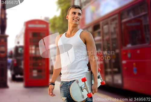 Image of smiling man with skateboard on london city street