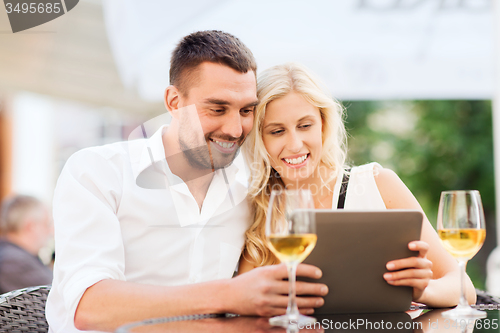 Image of happy couple with tablet pc at restaurant lounge