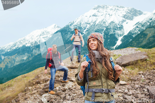 Image of group of smiling friends with backpacks hiking