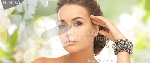 Image of woman with bracelets over natural background