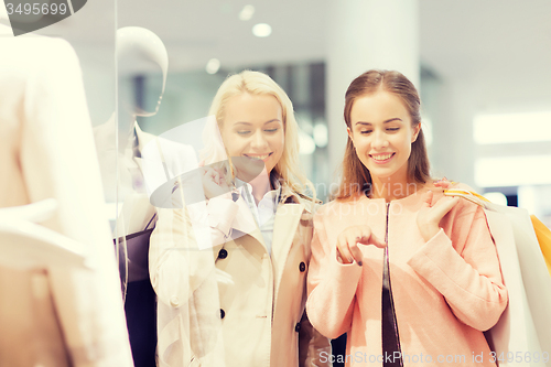 Image of happy young women with shopping bags in mall