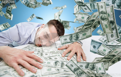 Image of happy businessman with heap of money