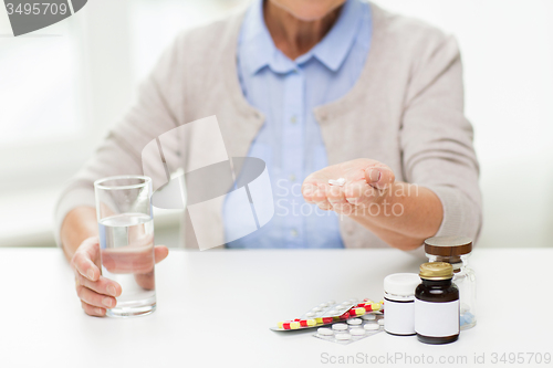 Image of close up of senior woman with water and pills