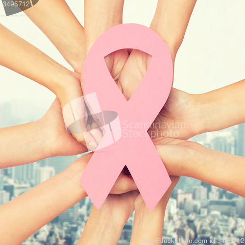 Image of close up of hands with cancer awareness symbol