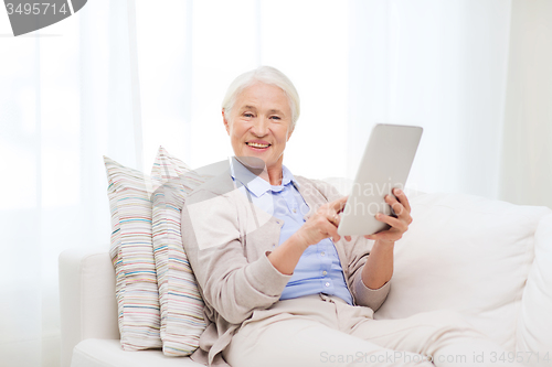 Image of happy senior woman with tablet pc at home