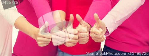 Image of close up of women in pink shirts showing thumbs up