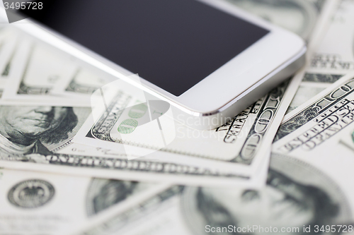 Image of close up of smartphone and dollar money