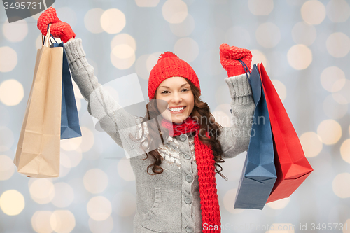 Image of happy woman in winter clothes with shopping bags