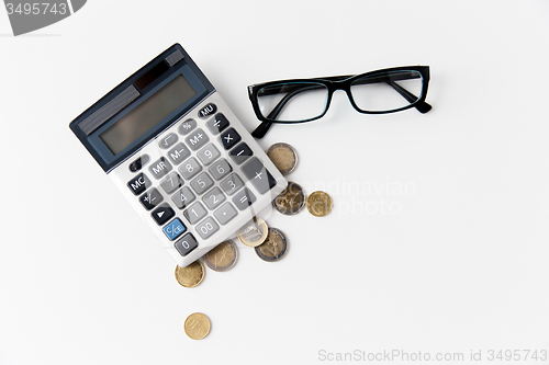 Image of calculator, eyeglasses and euro coins on table