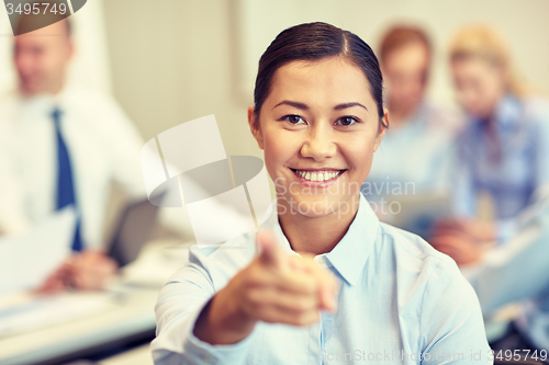 Image of group of smiling businesspeople meeting in office