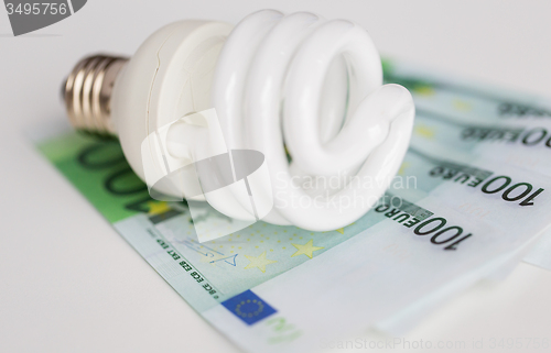 Image of close up of euro money and light bulb on table