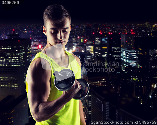 Image of young man with dumbbell flexing biceps