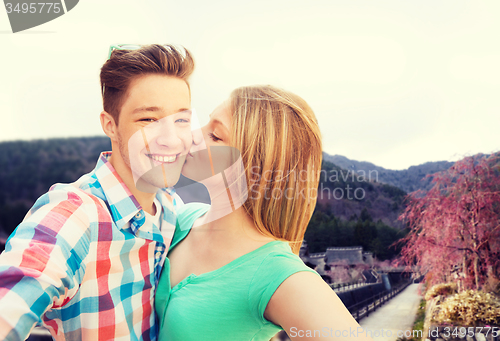 Image of couple kissing and taking selfie over asian town