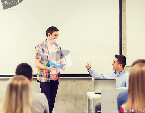 Image of group of smiling students and teacher in classroom