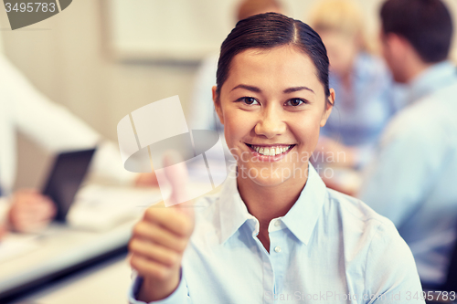 Image of group of smiling businesspeople meeting in office