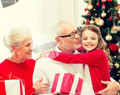 Image of smiling family with gifts at home