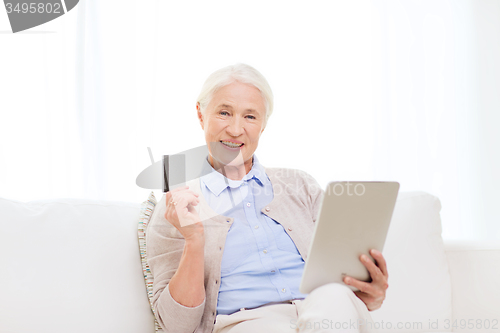 Image of senior woman with tablet pc and credit card