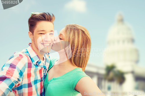 Image of couple kissing and taking selfie over white house