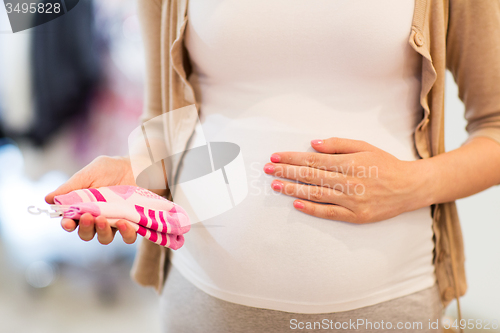 Image of pregnant woman with baby socks at clothing store