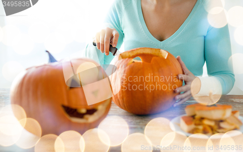 Image of close up of woman with pumpkins at home