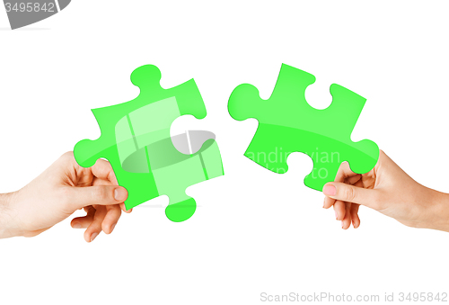 Image of close up of couple hands with green puzzle pieces