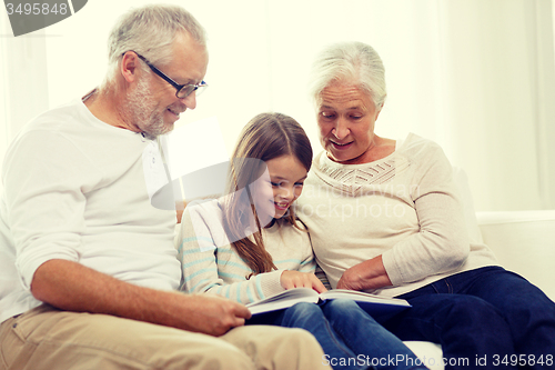 Image of smiling family with book at home