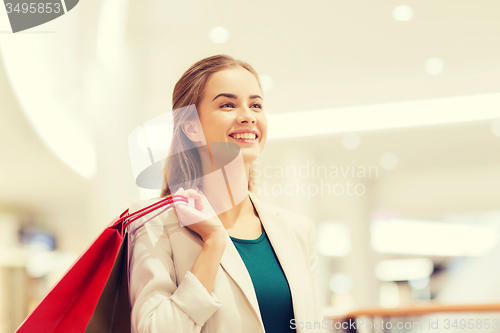 Image of happy young woman with shopping bags in mall