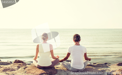 Image of couple making yoga exercises outdoors