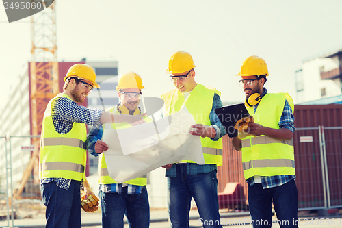 Image of group of builders with tablet pc and blueprint