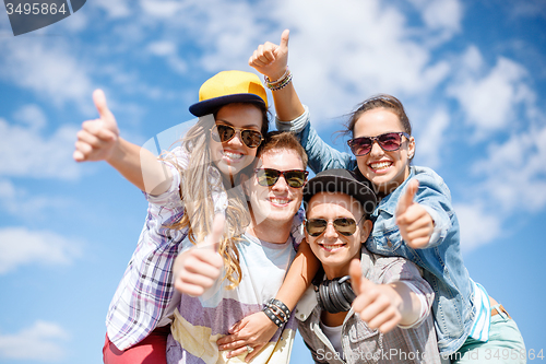 Image of smiling teenagers in sunglasses hanging outside