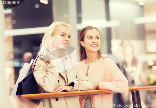 Image of happy young women with shopping bags in mall